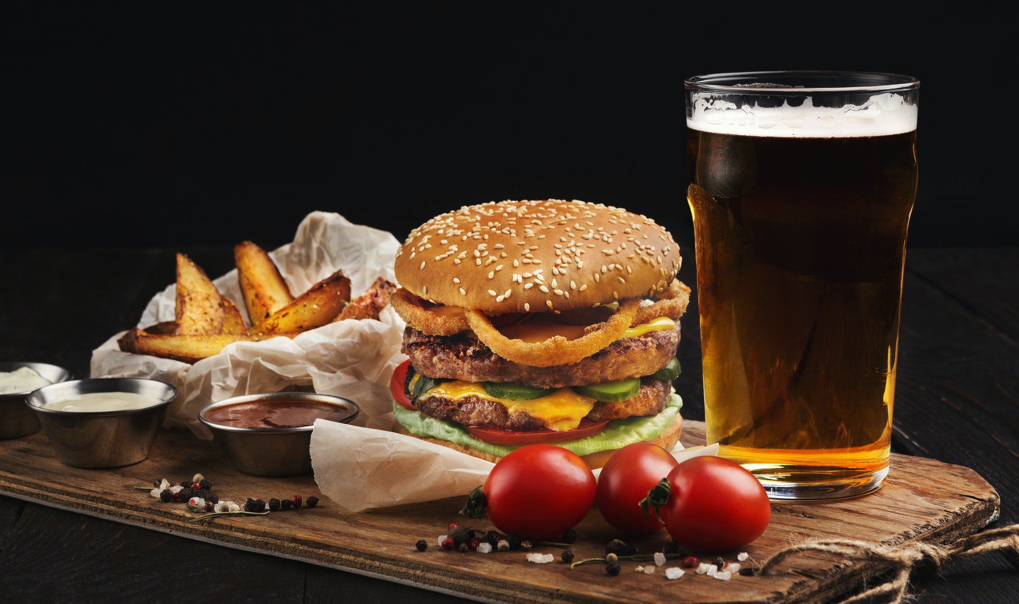 Hamburger made of beef and beer on wooden cutting board